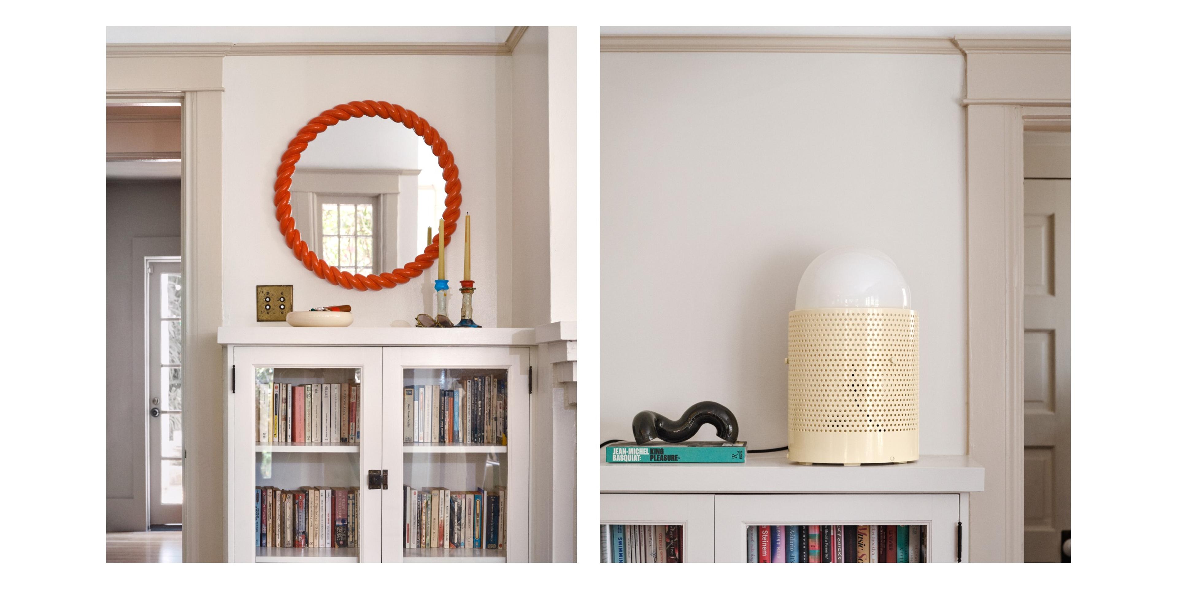 Built-in bookcases with modern lamp and red mirror.