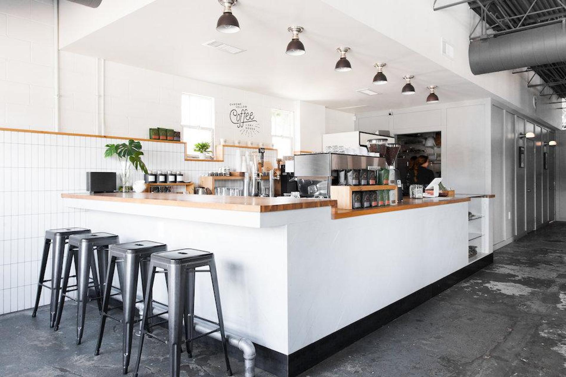 room with stools and tables at a coffee shop