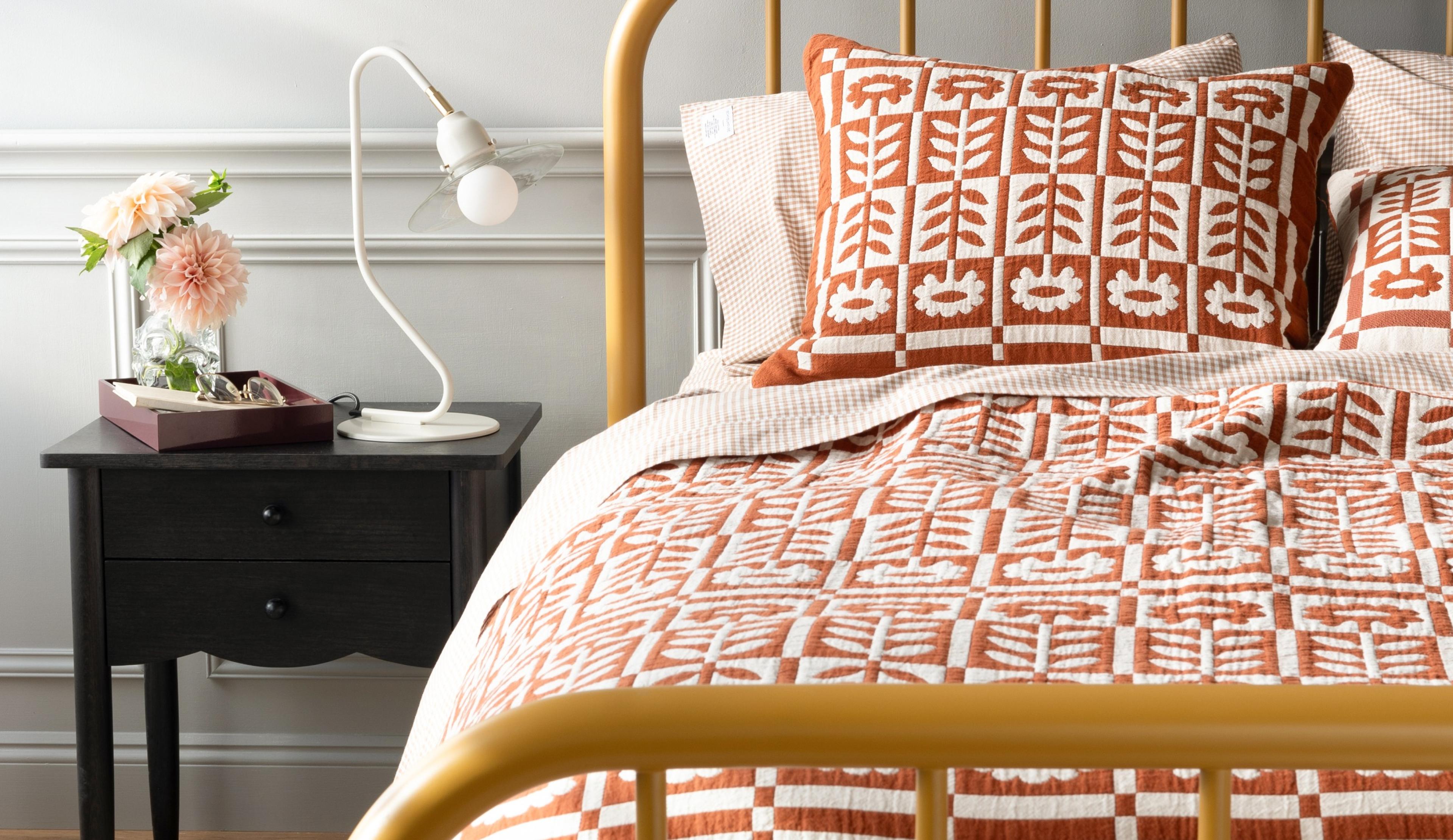 Floral quilt on a yellow bed frame. 