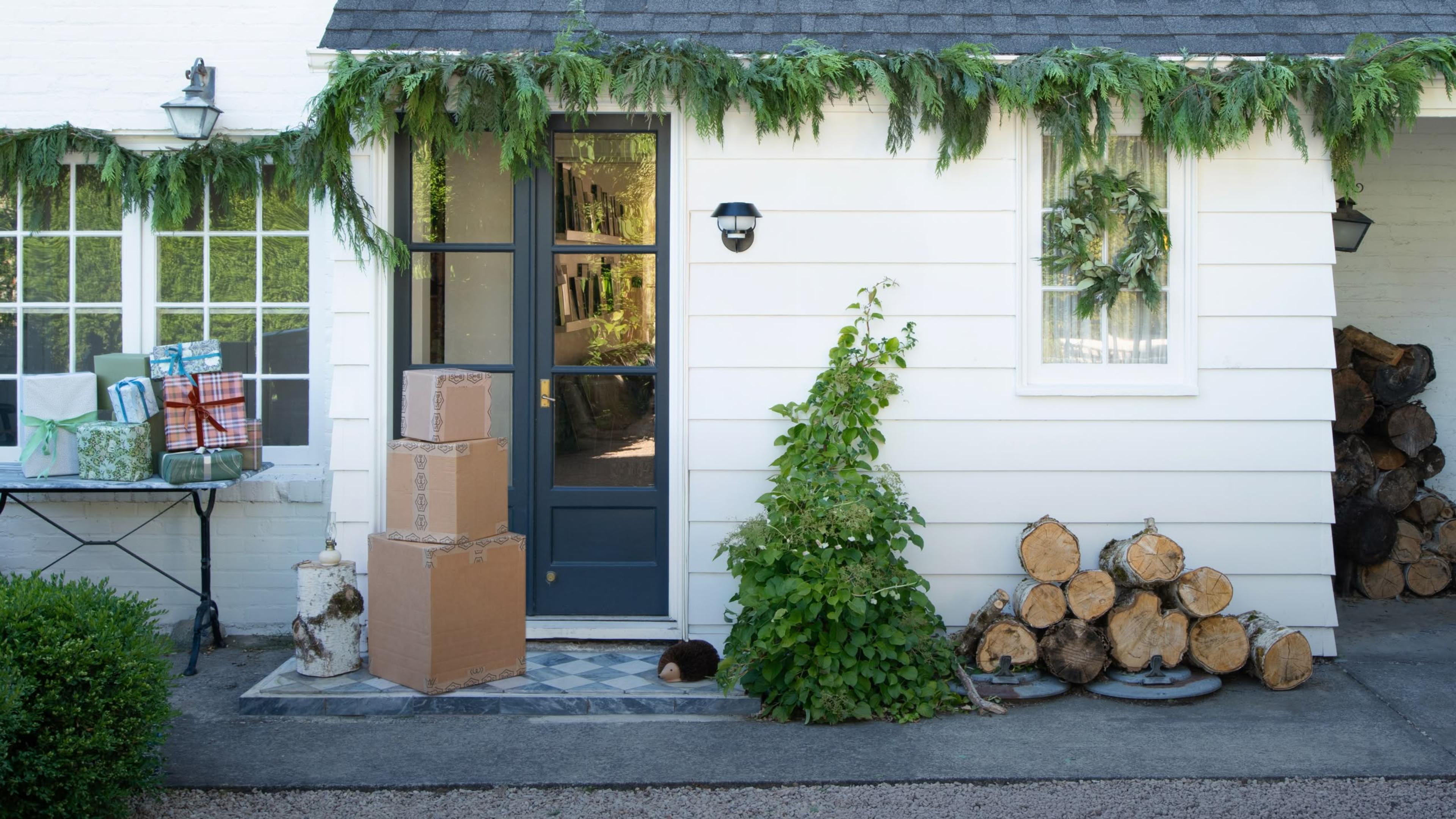 Exterior of white home with stacked shipping boxes