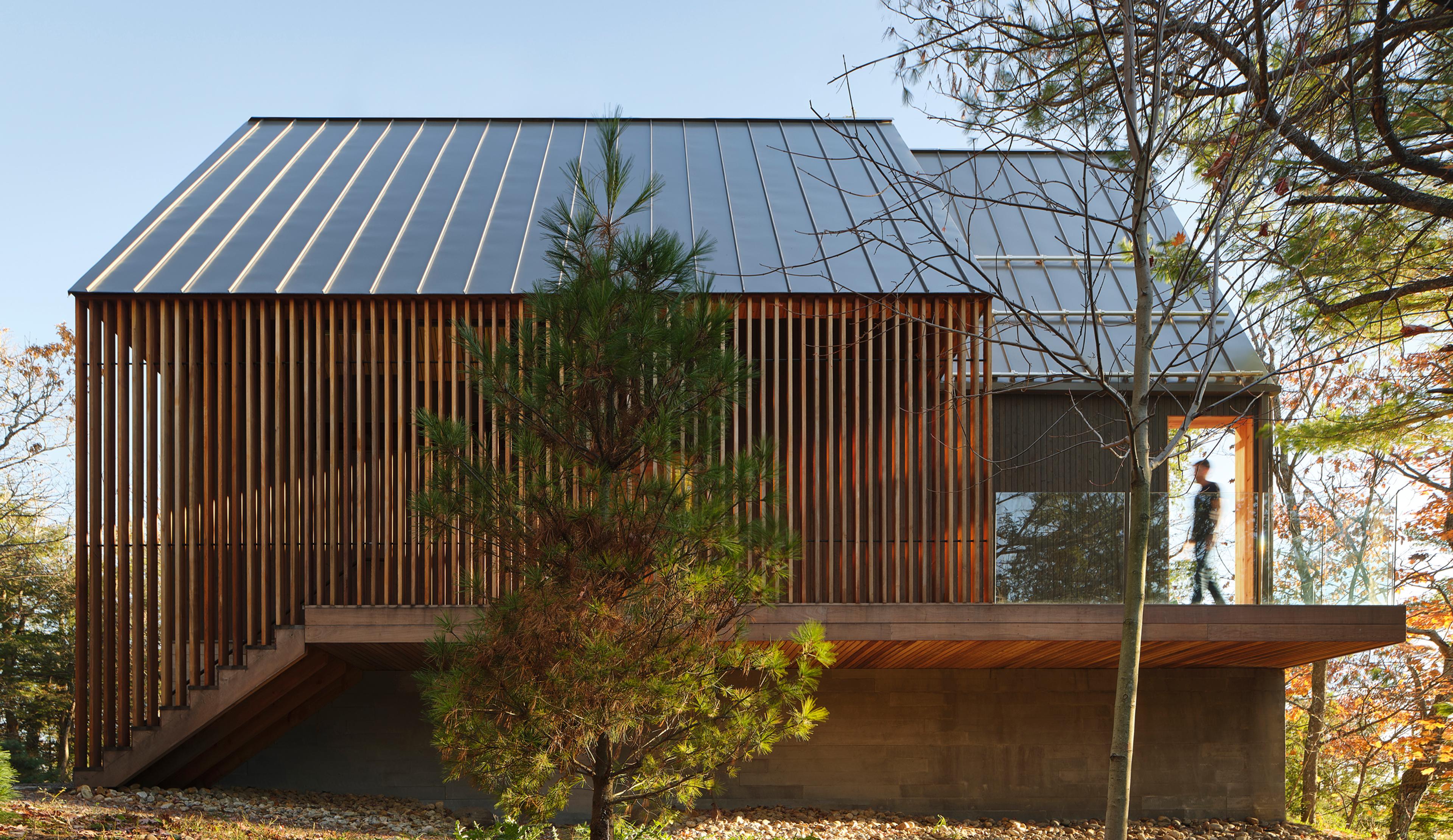 A modern home with a tree in front of it.