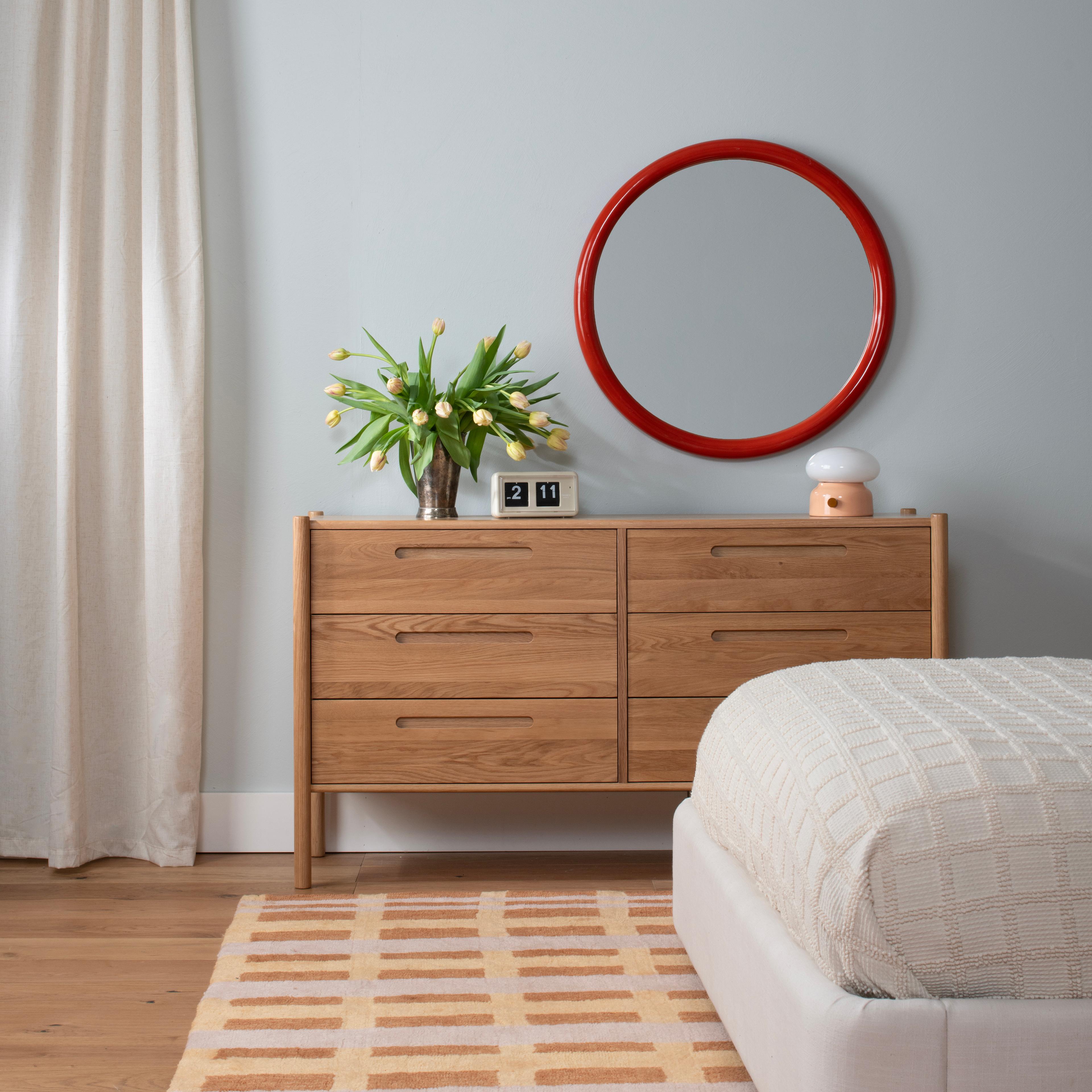 bedroom studio with round mirror and stools in different colors 