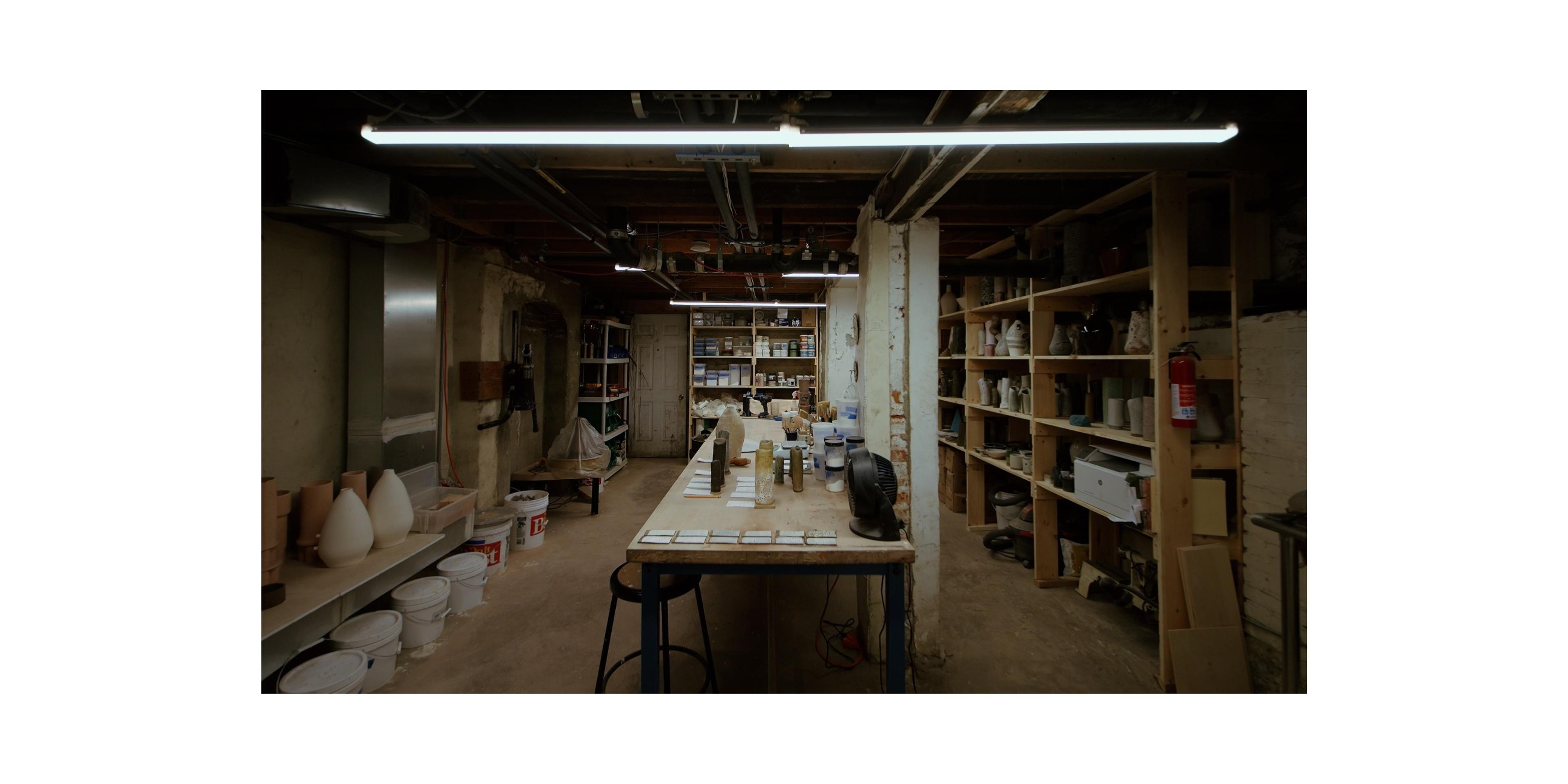 Basement ceramics studio with industrial overhead lighting