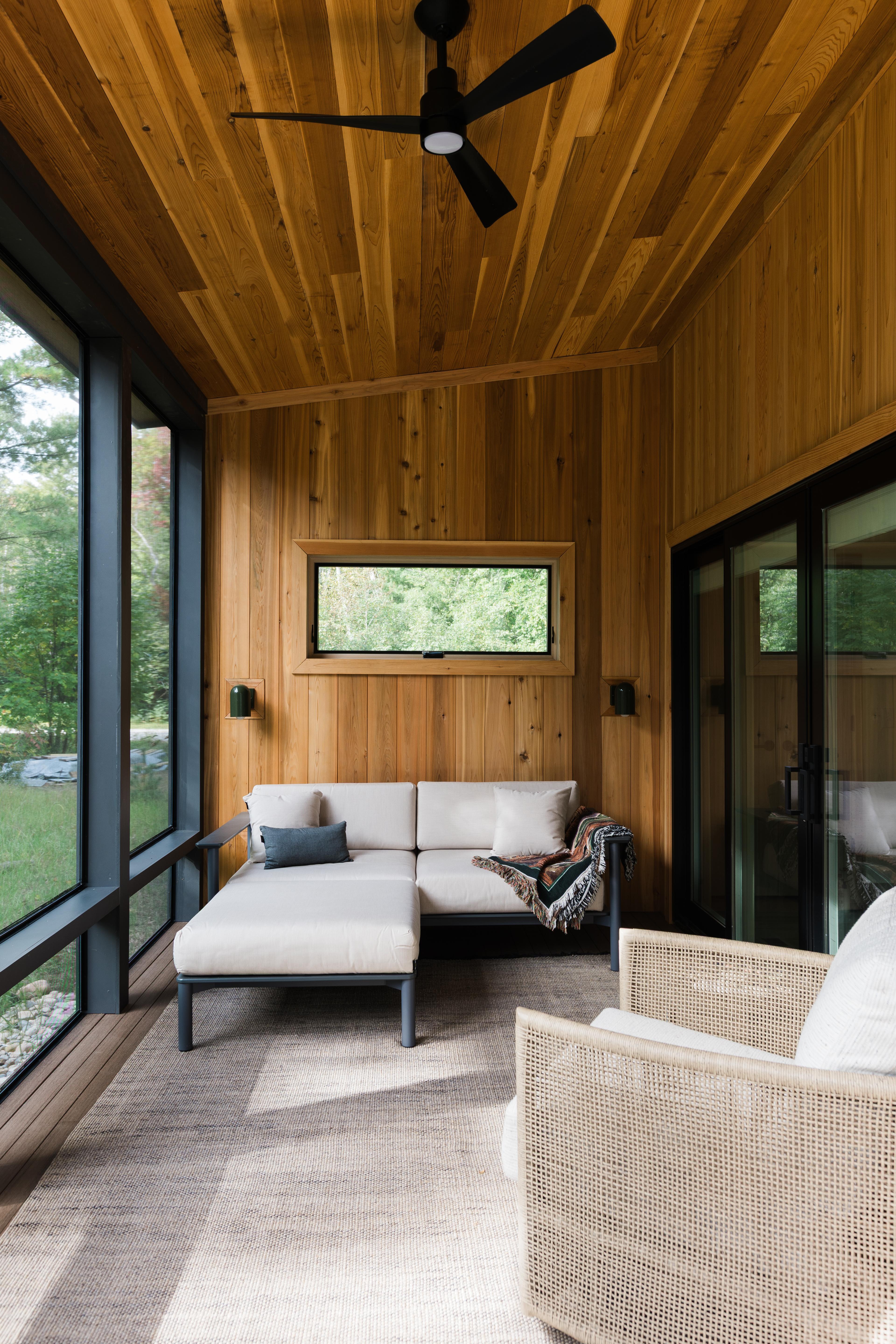 Living room with sofa and sconces and ceiling fan.