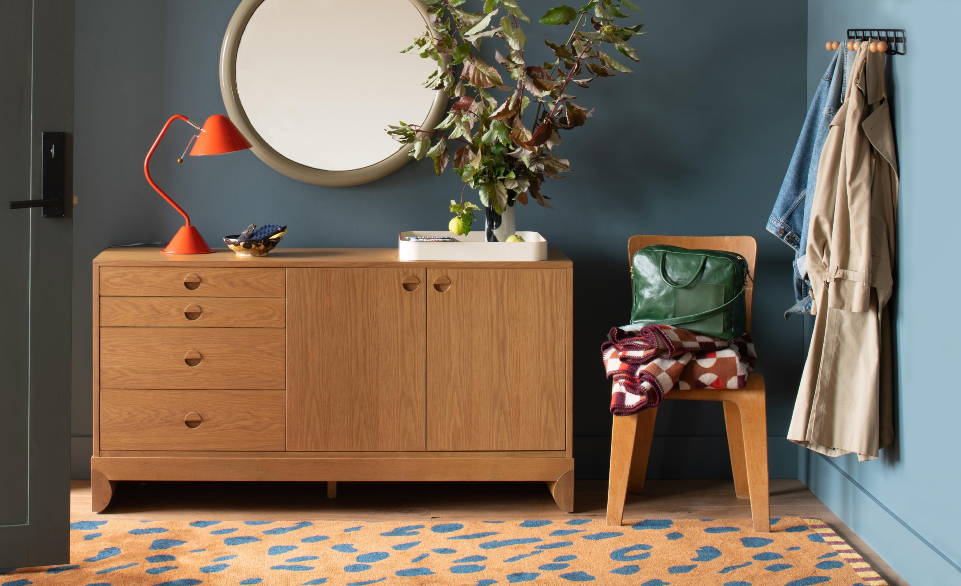 Entry way with wooden sideboard, wooden chair & peg rail with hanging jackets