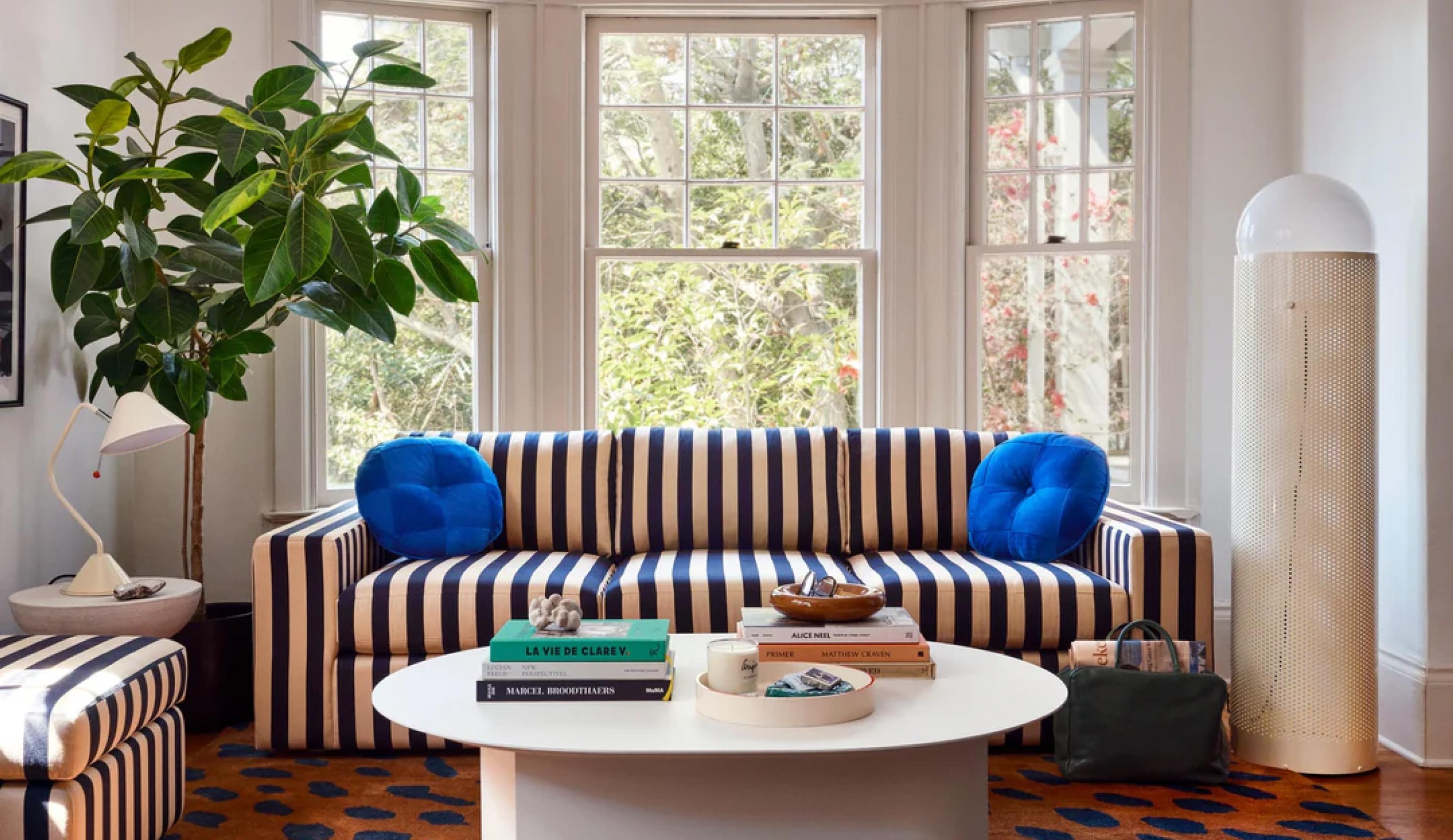 Striped couch with blue pillows. 