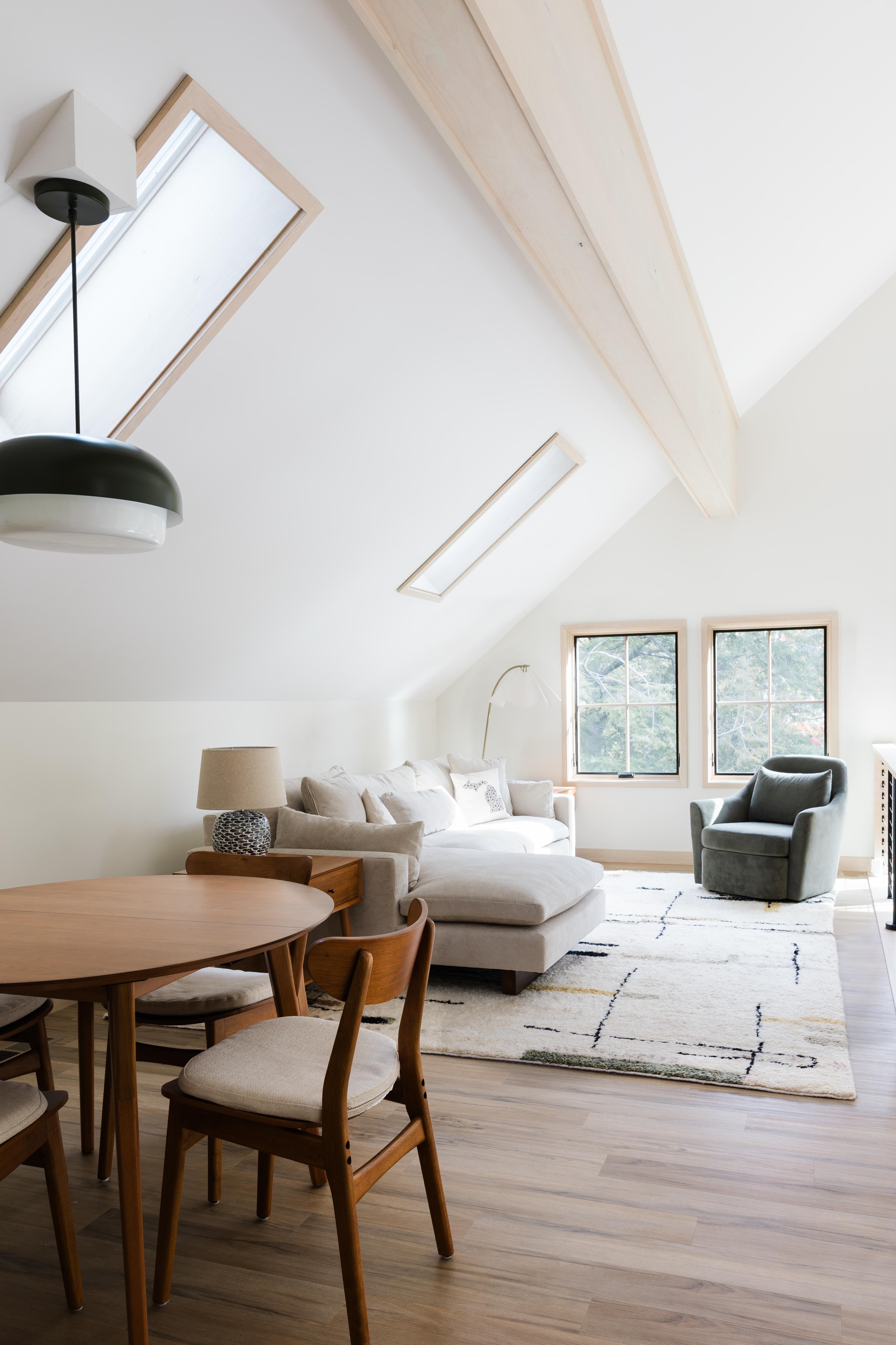 Neutral living and dining room with Schoolhouse ay pendant.