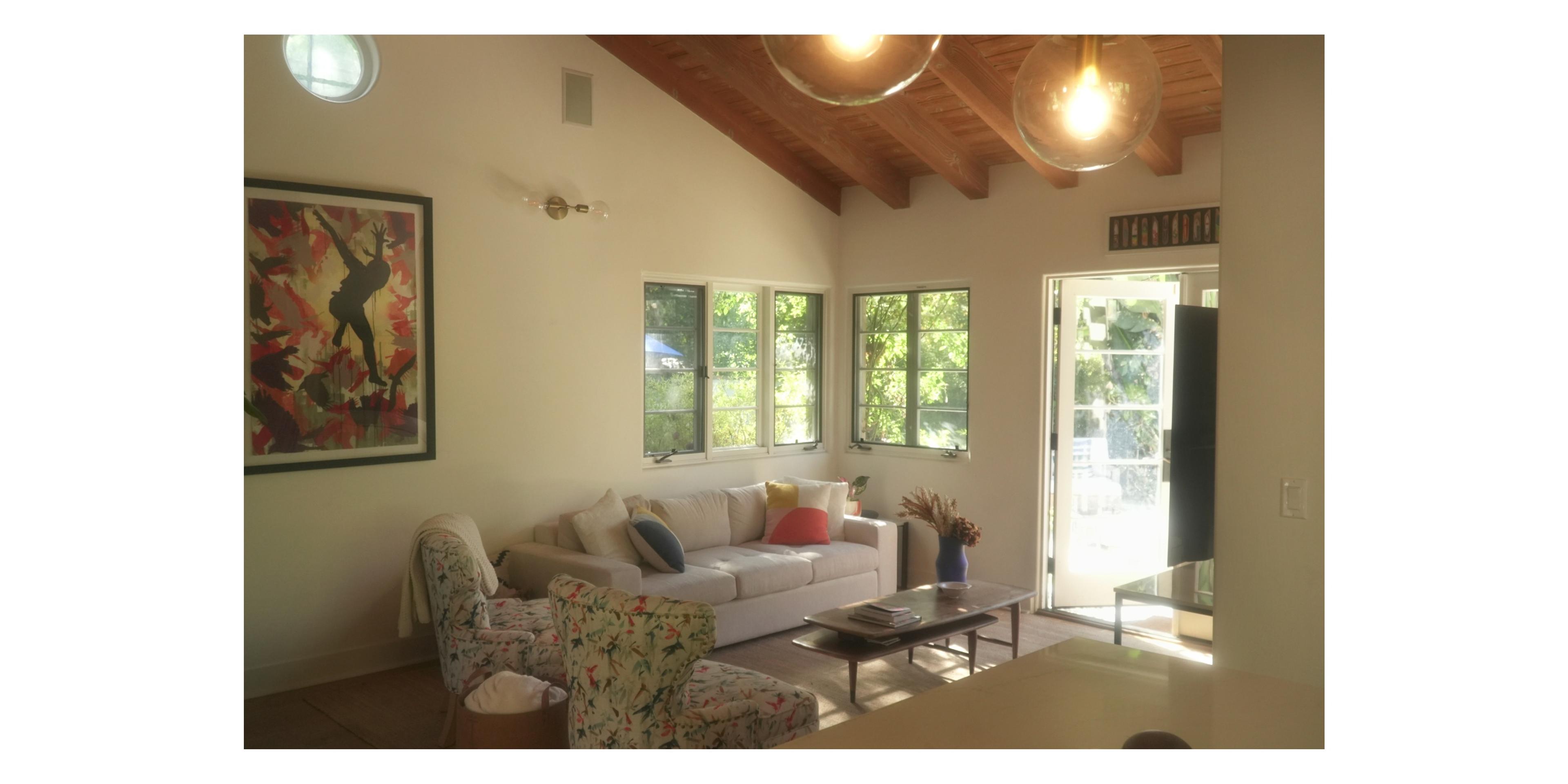 2nd living room with white couch and open door leading to outside