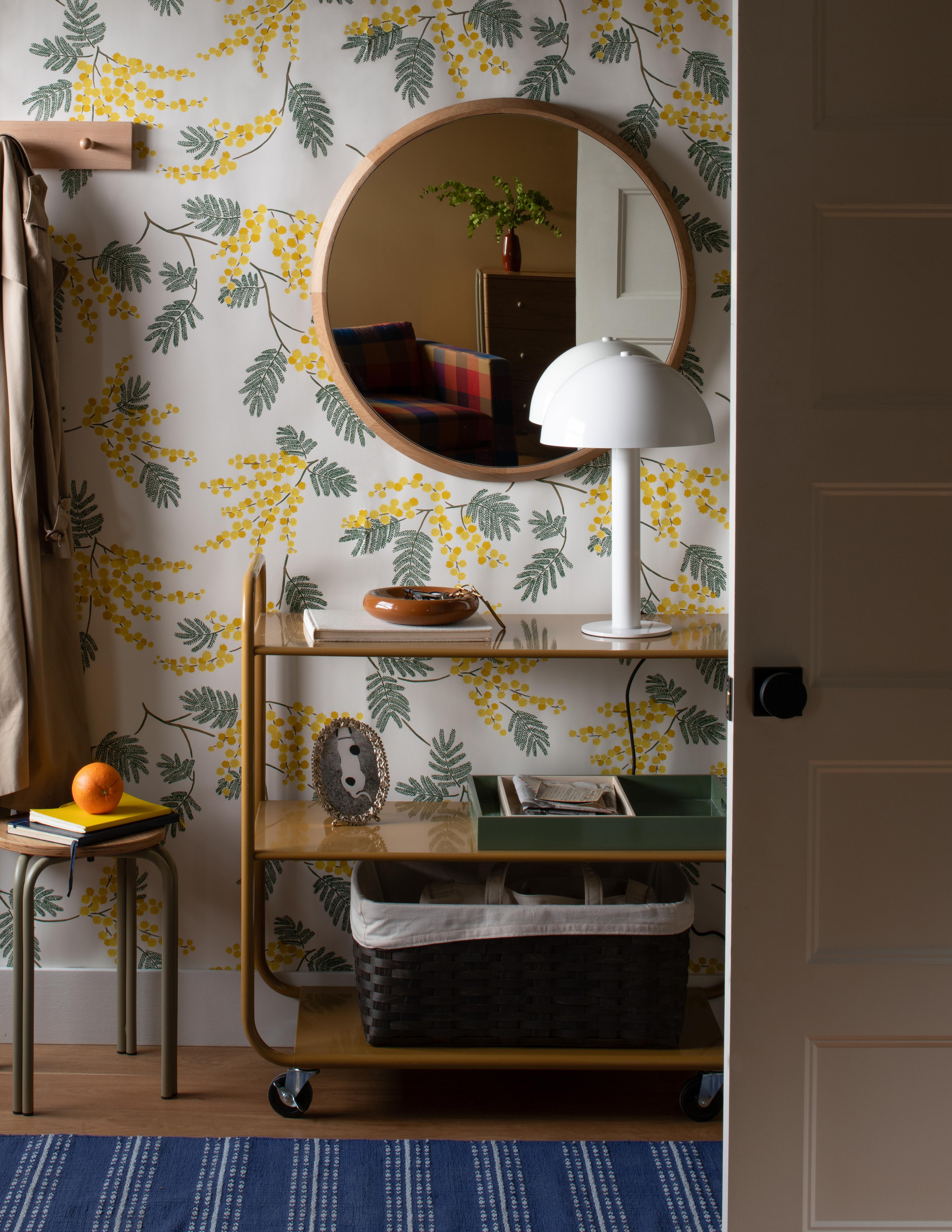 Entry way with floral wallpaper and utility cart used for keepsakes and catchall for keys
