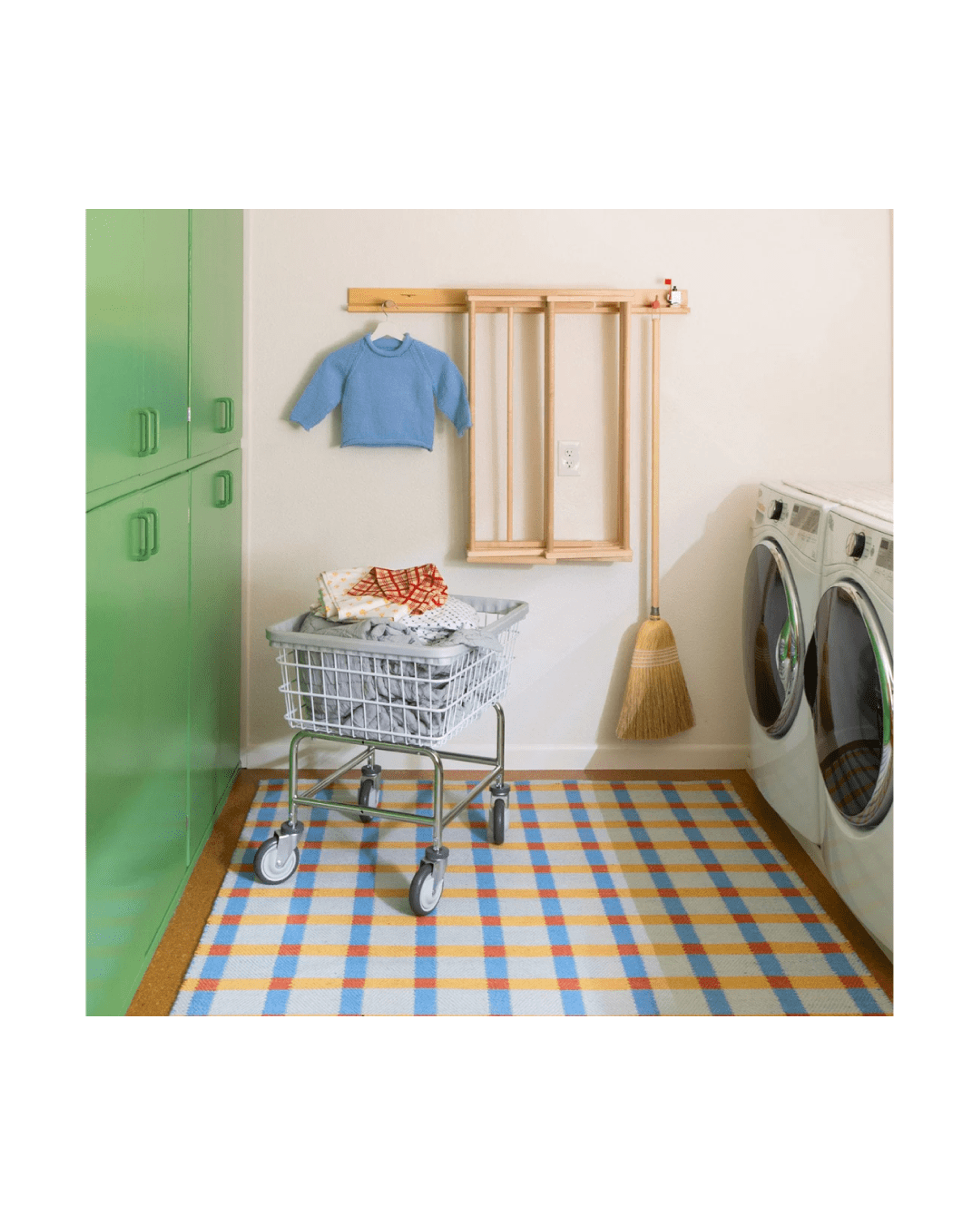 Colorful laundry room with green cabinets.