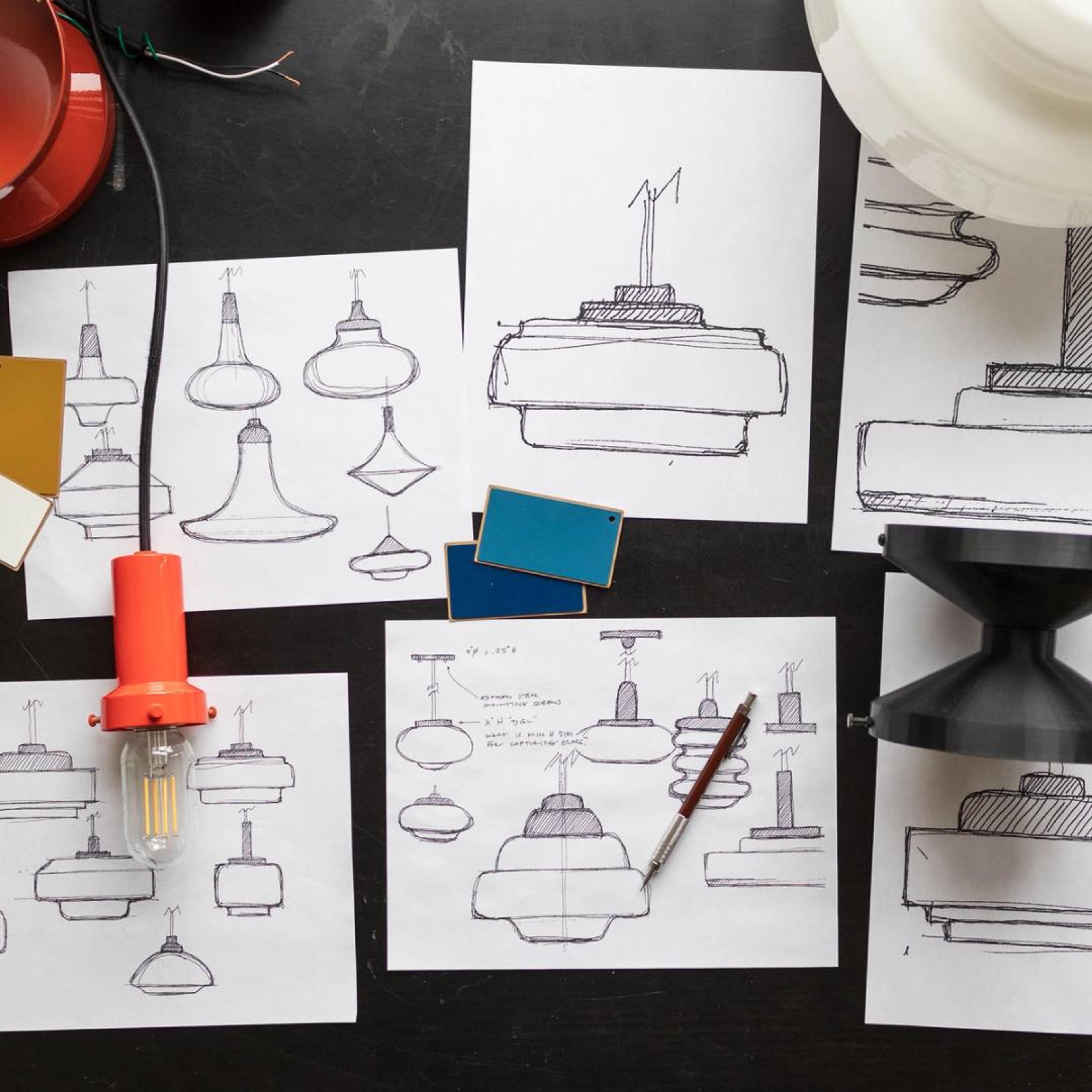 Lighting fixture sketches on a table with lighting fixtures