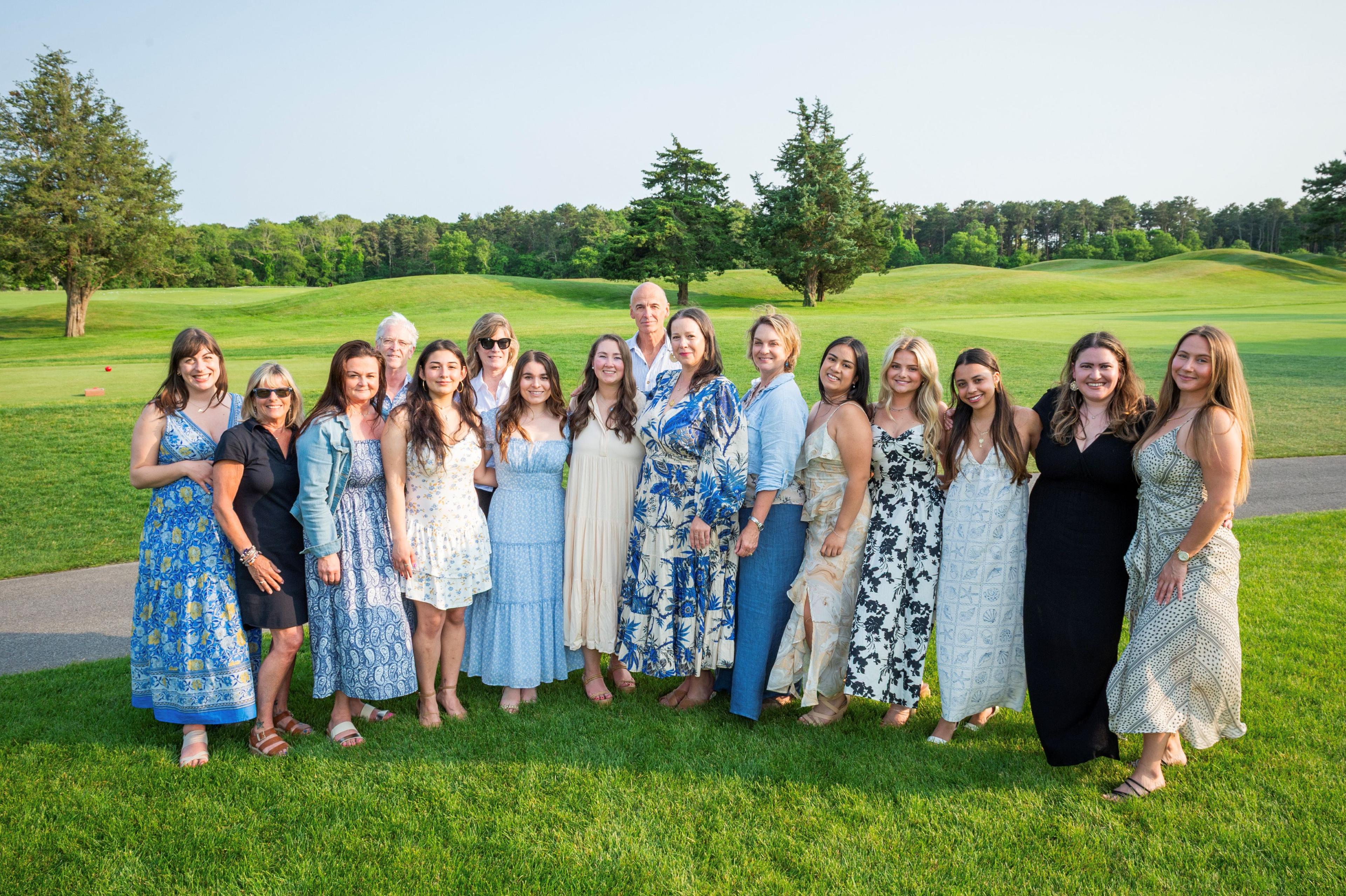 Group of people posing in a field. 