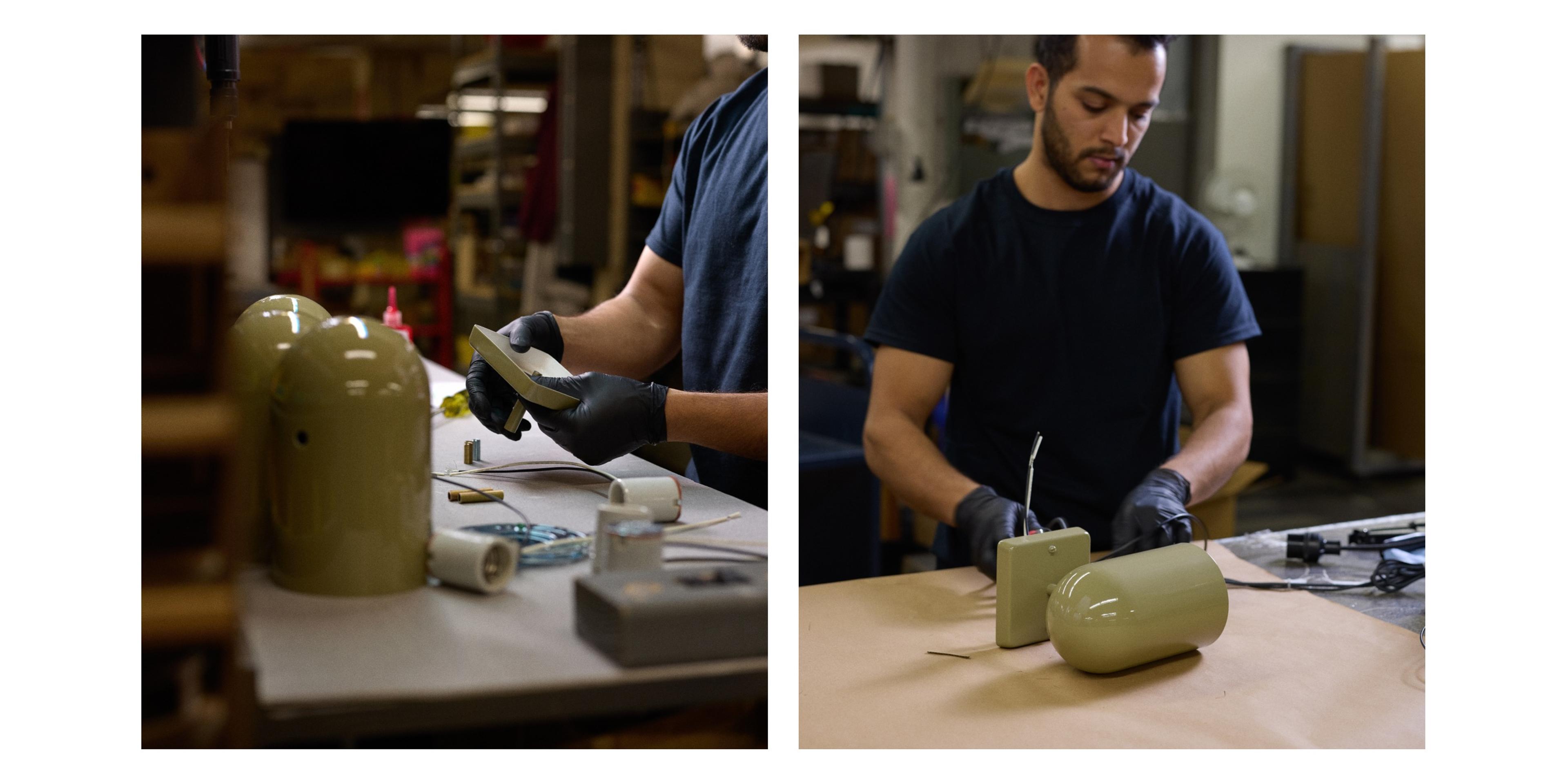 Factory employee assembling sage green sconce with wiring 