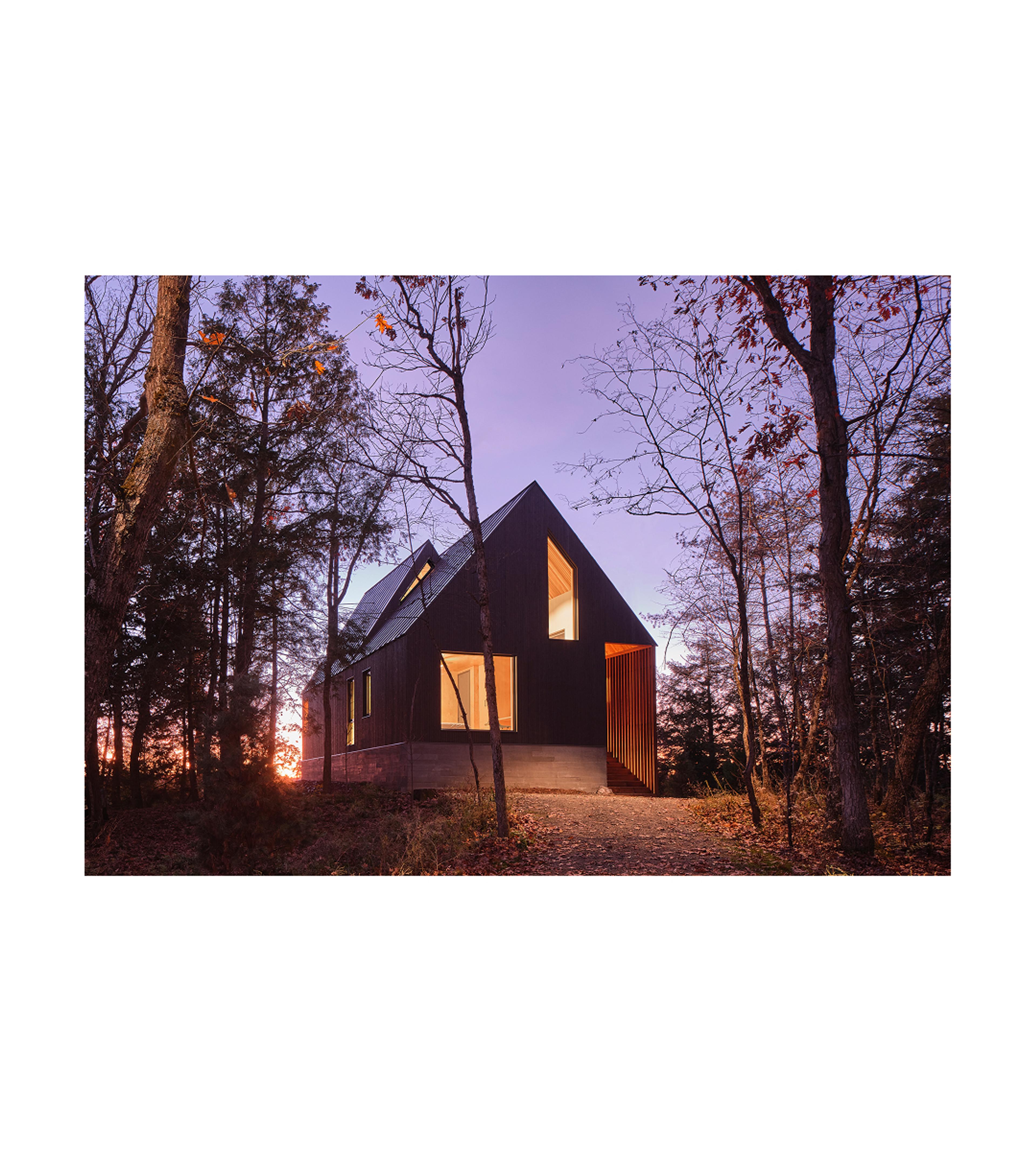 A-frame house with a purple sunset behind it.
