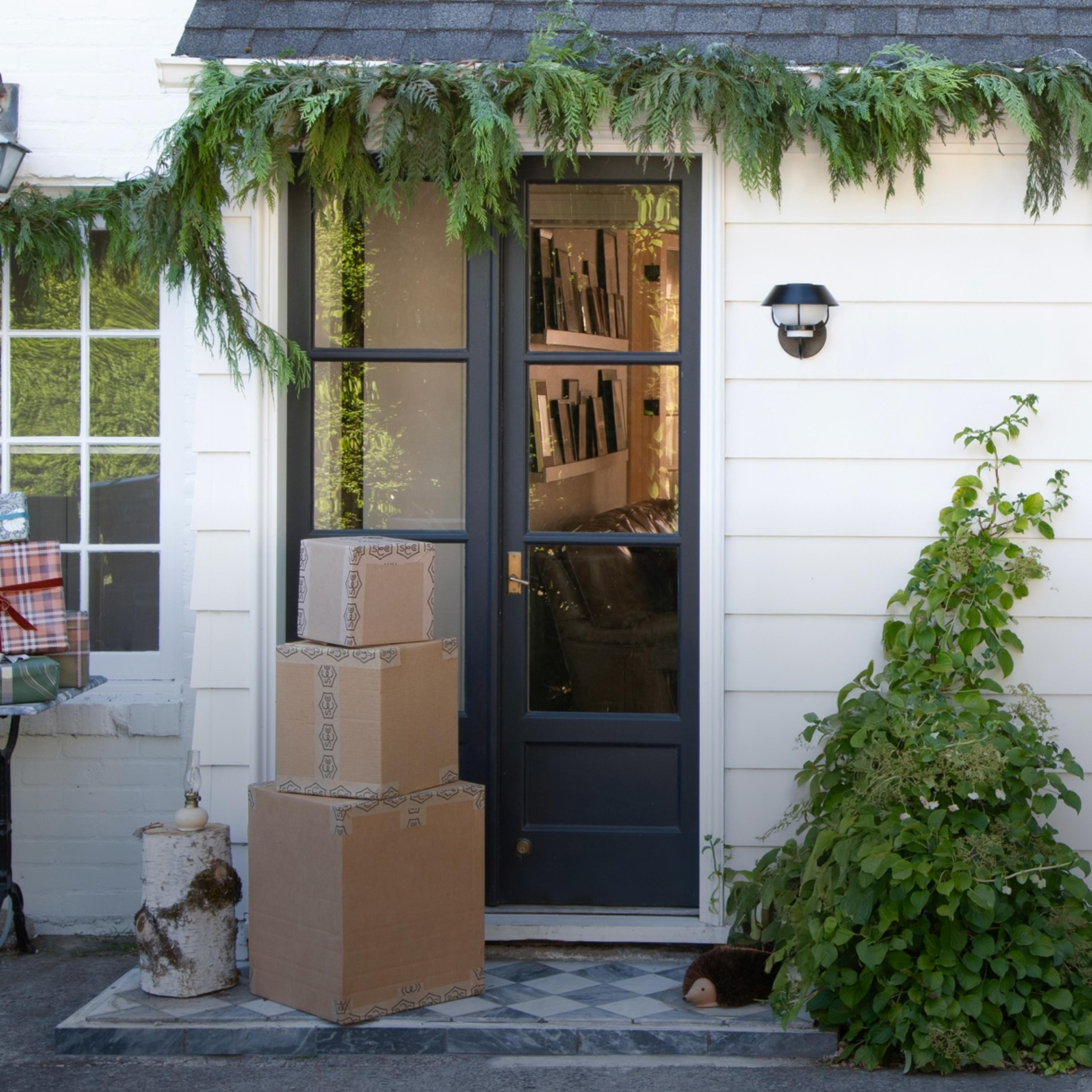 Exterior of white home with stacked shipping boxes