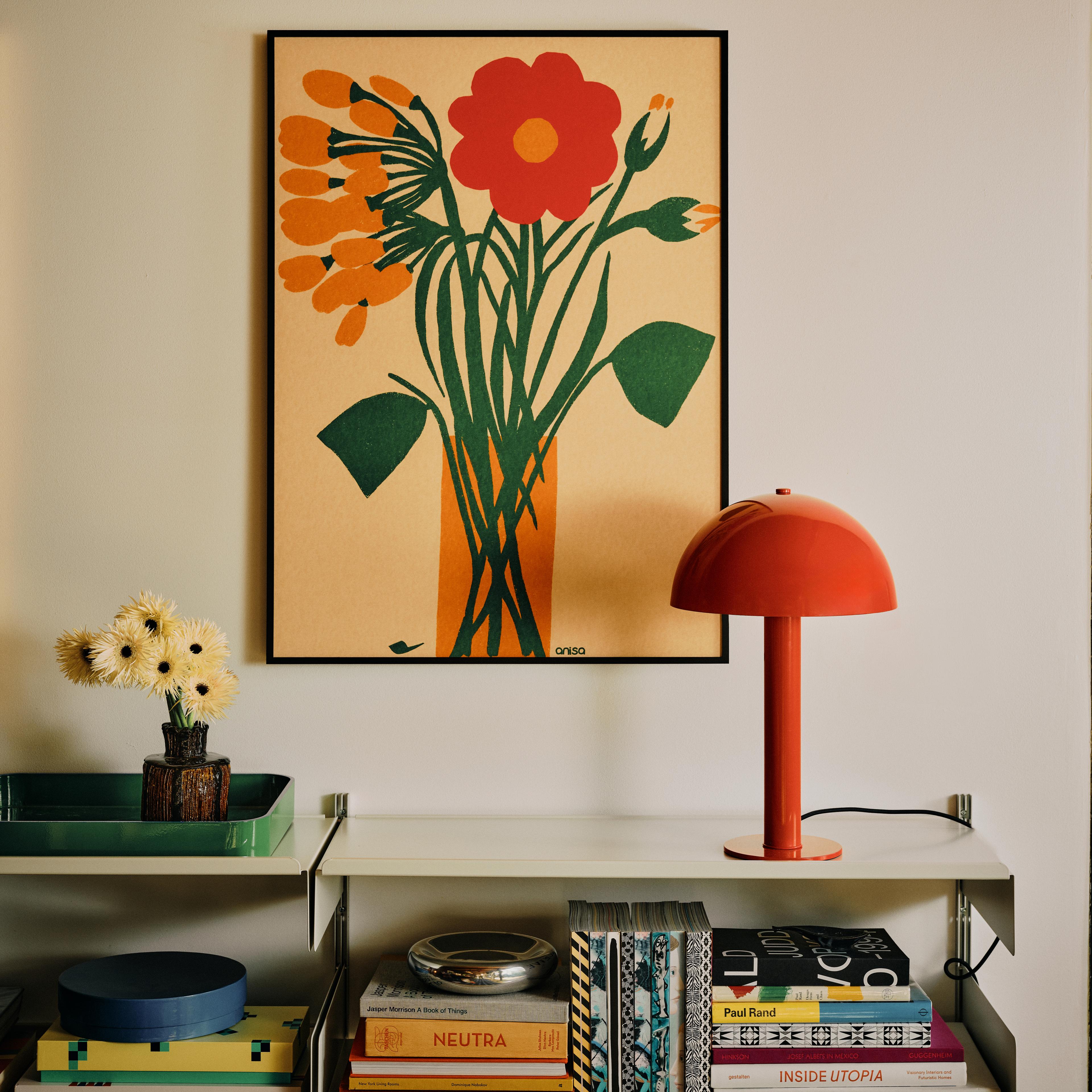 Floral print above shelving unit with red mushroom shaped lamp