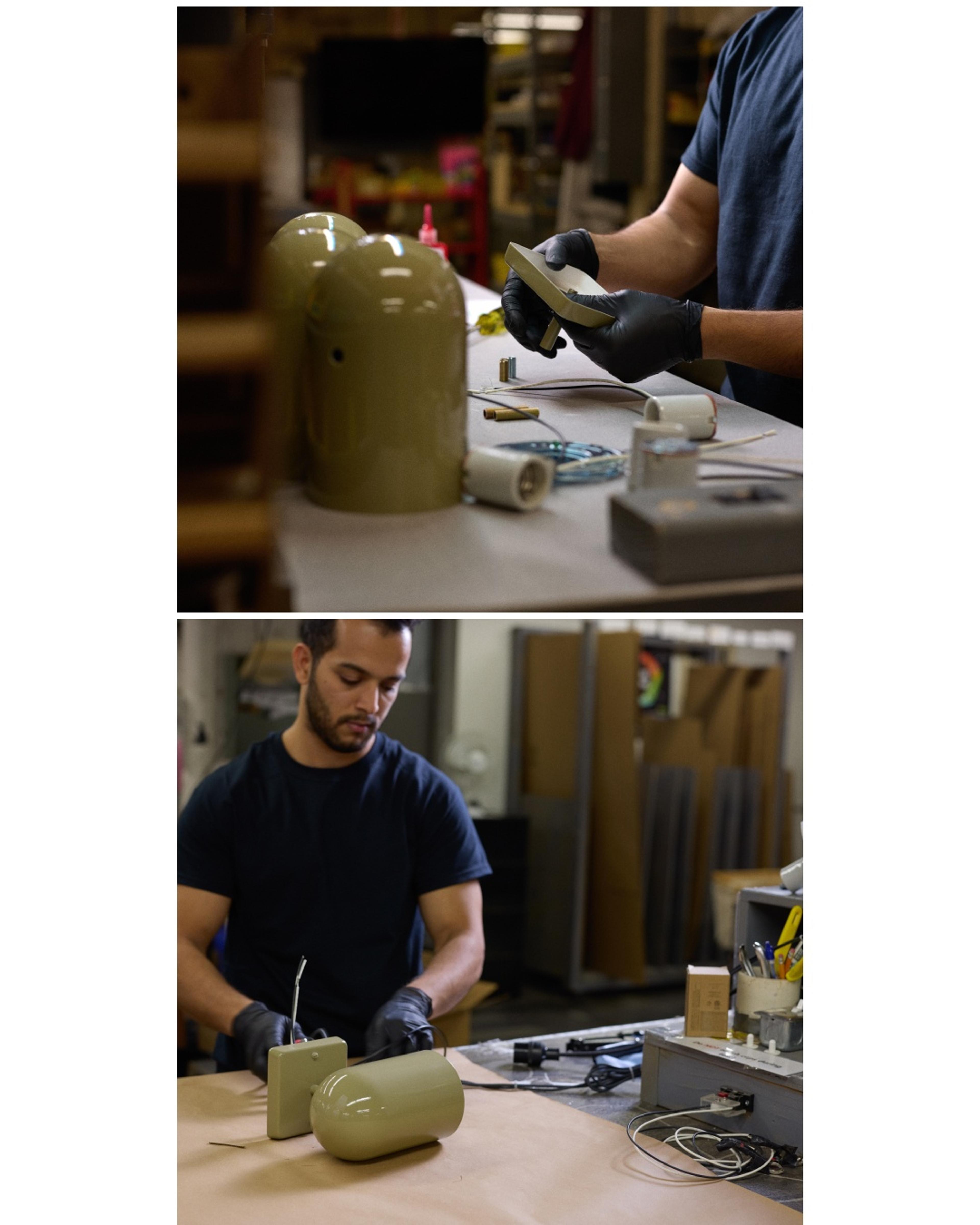 Factory employee assembling sage green sconce with wiring 