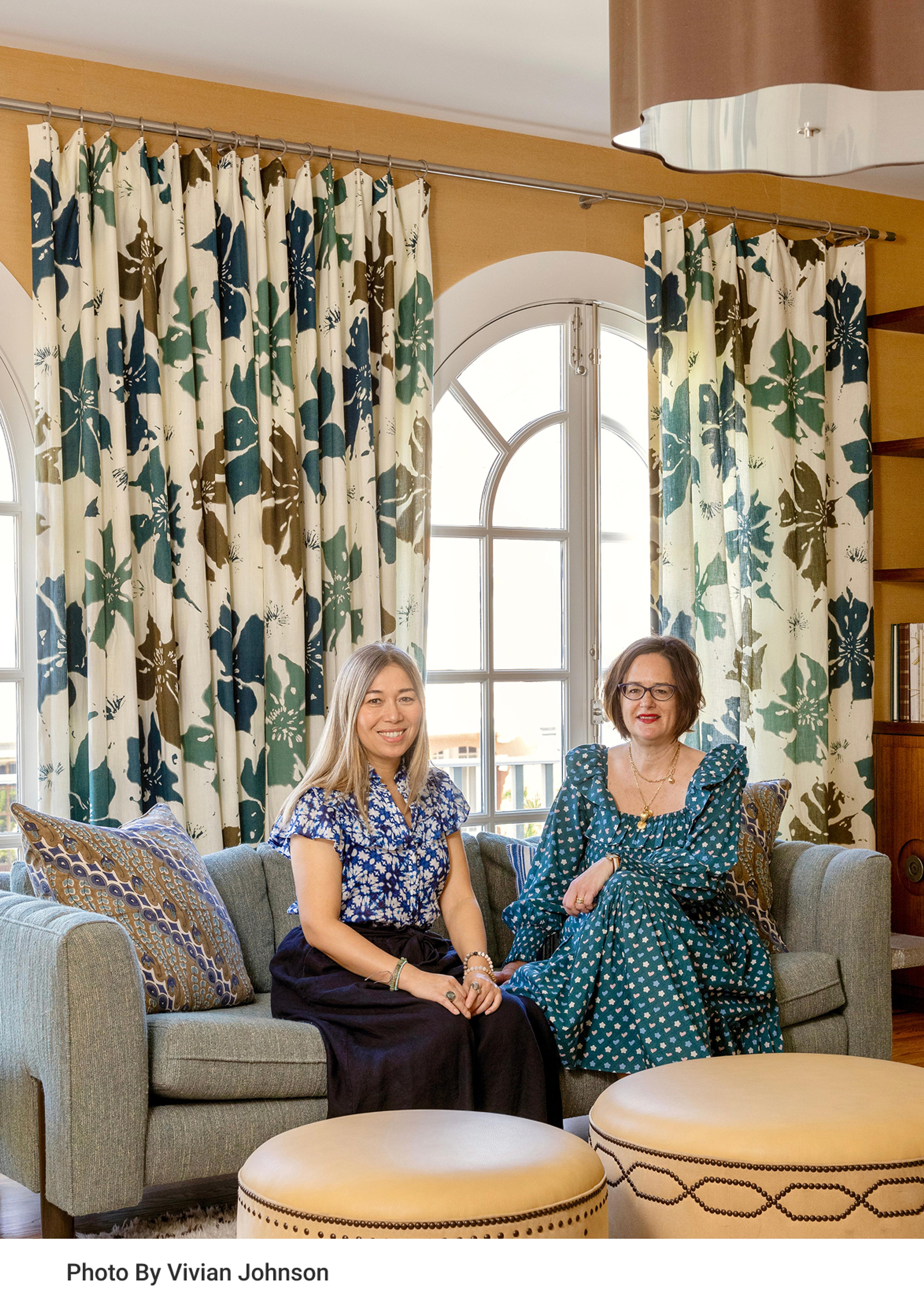 Two woman sitting in a colorful living room.