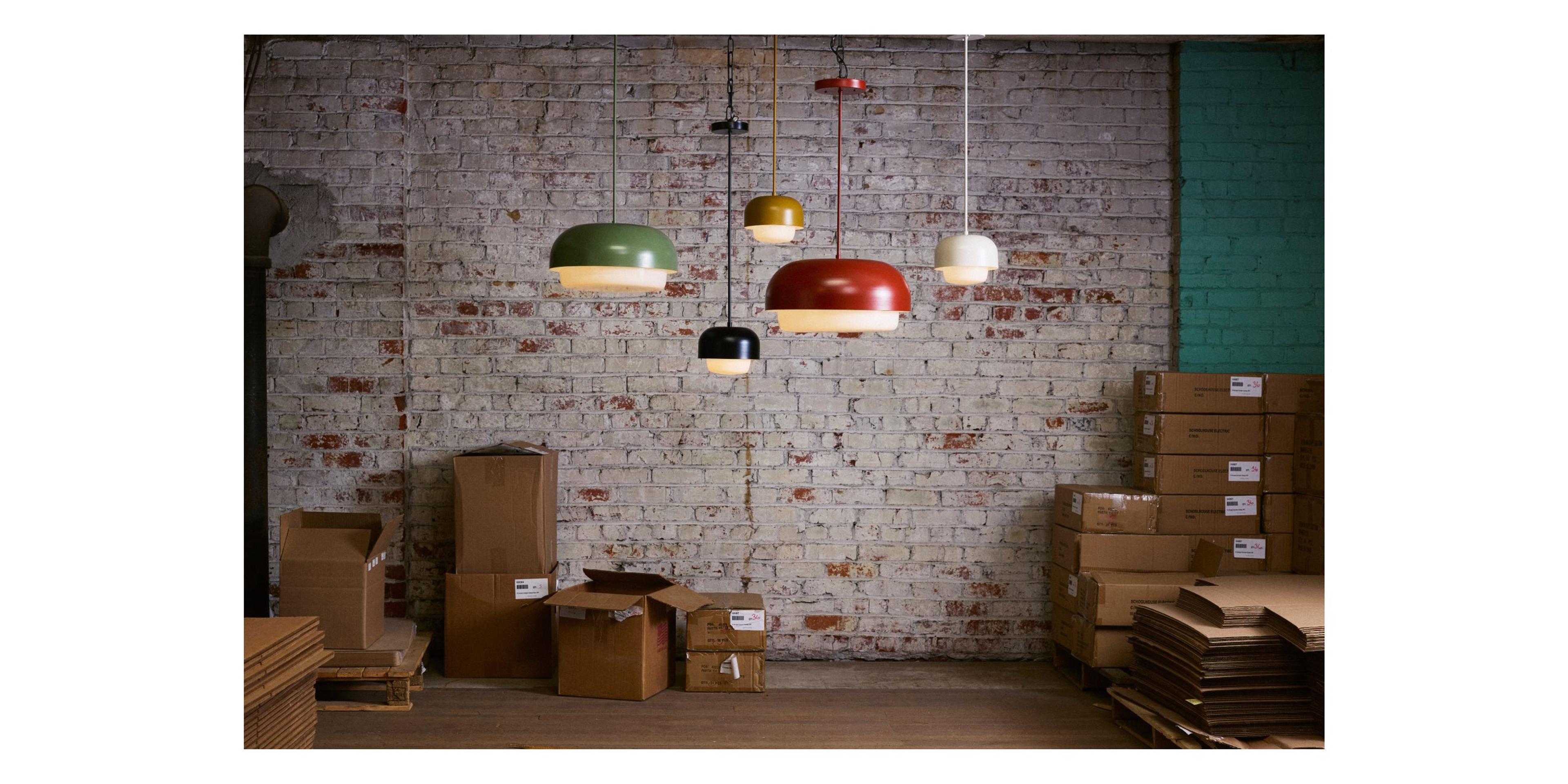 5 pendant lamps in different colors in front of brick wall