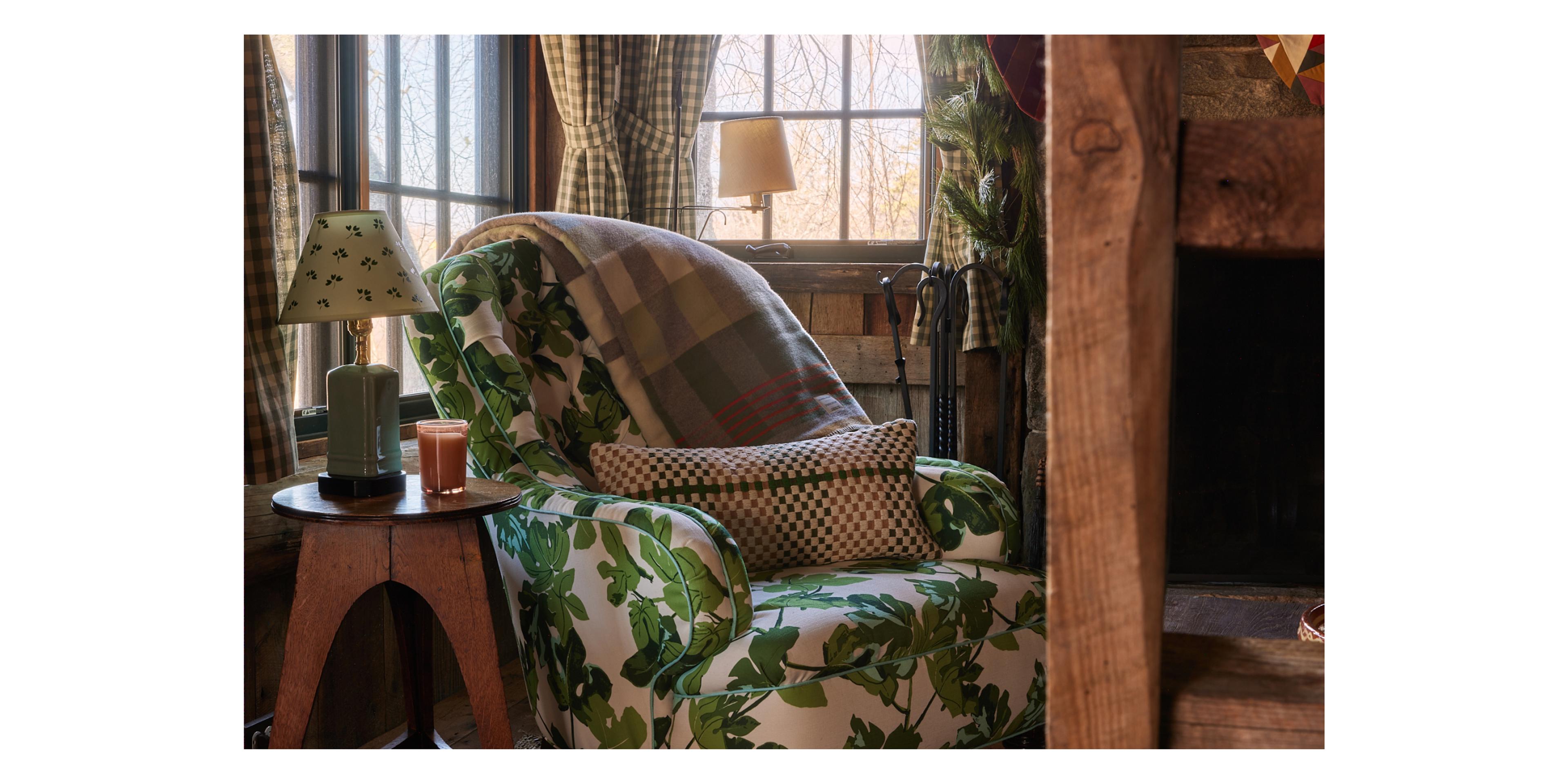 accent chair in wooden cabin living room with green wool blanket