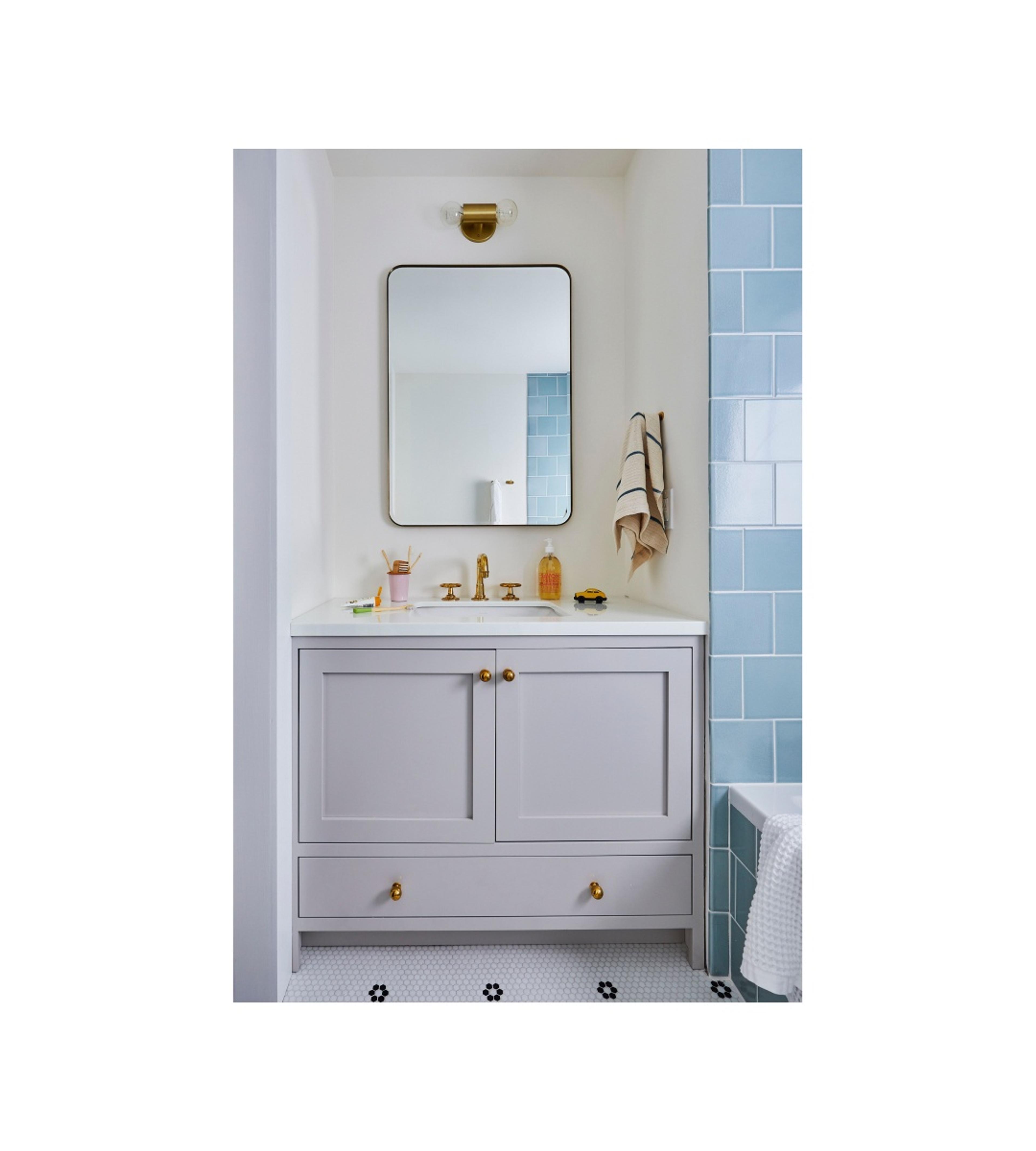 Serene bathroom with blue tile and white walls. 