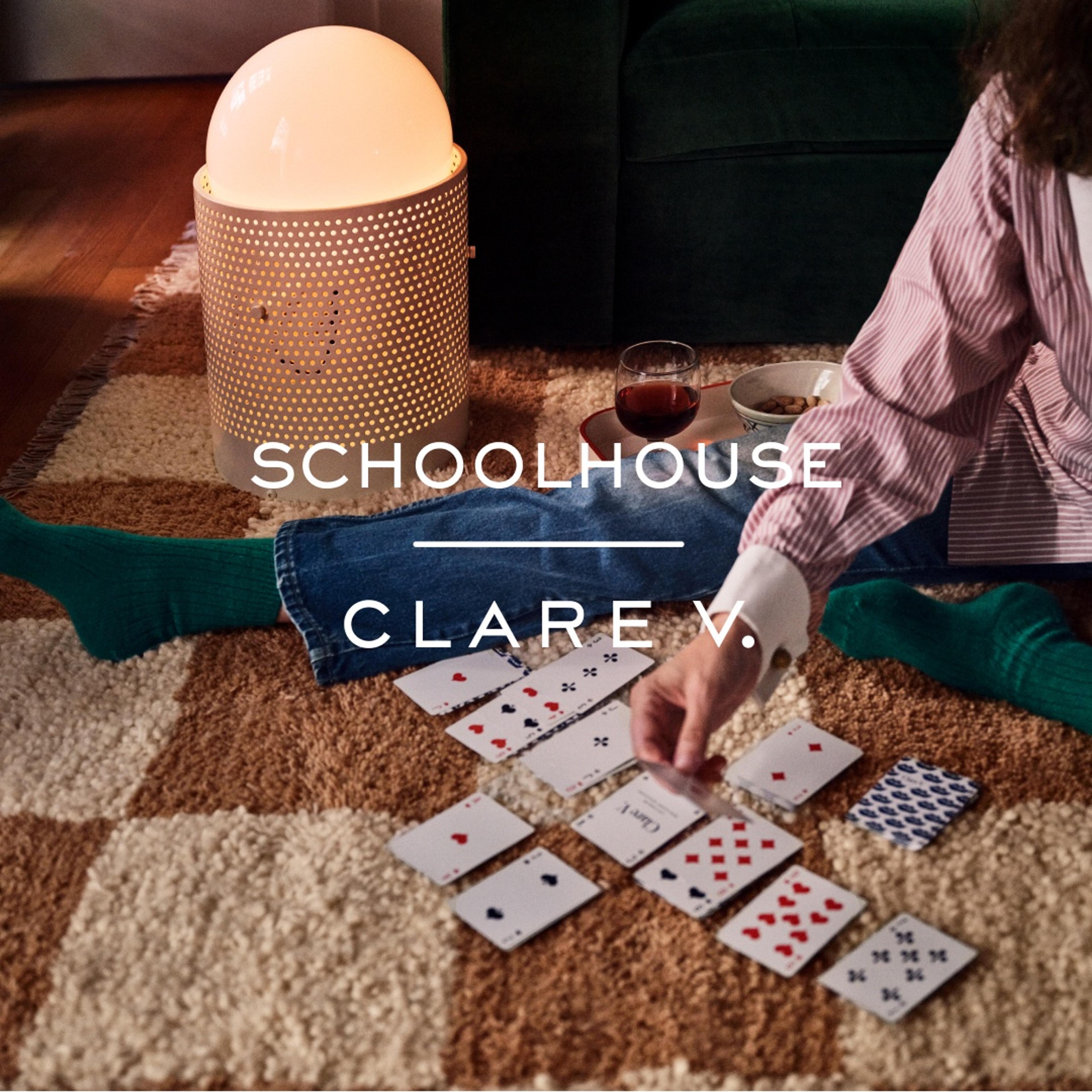 Person sitting on a checkboard rug playing cards