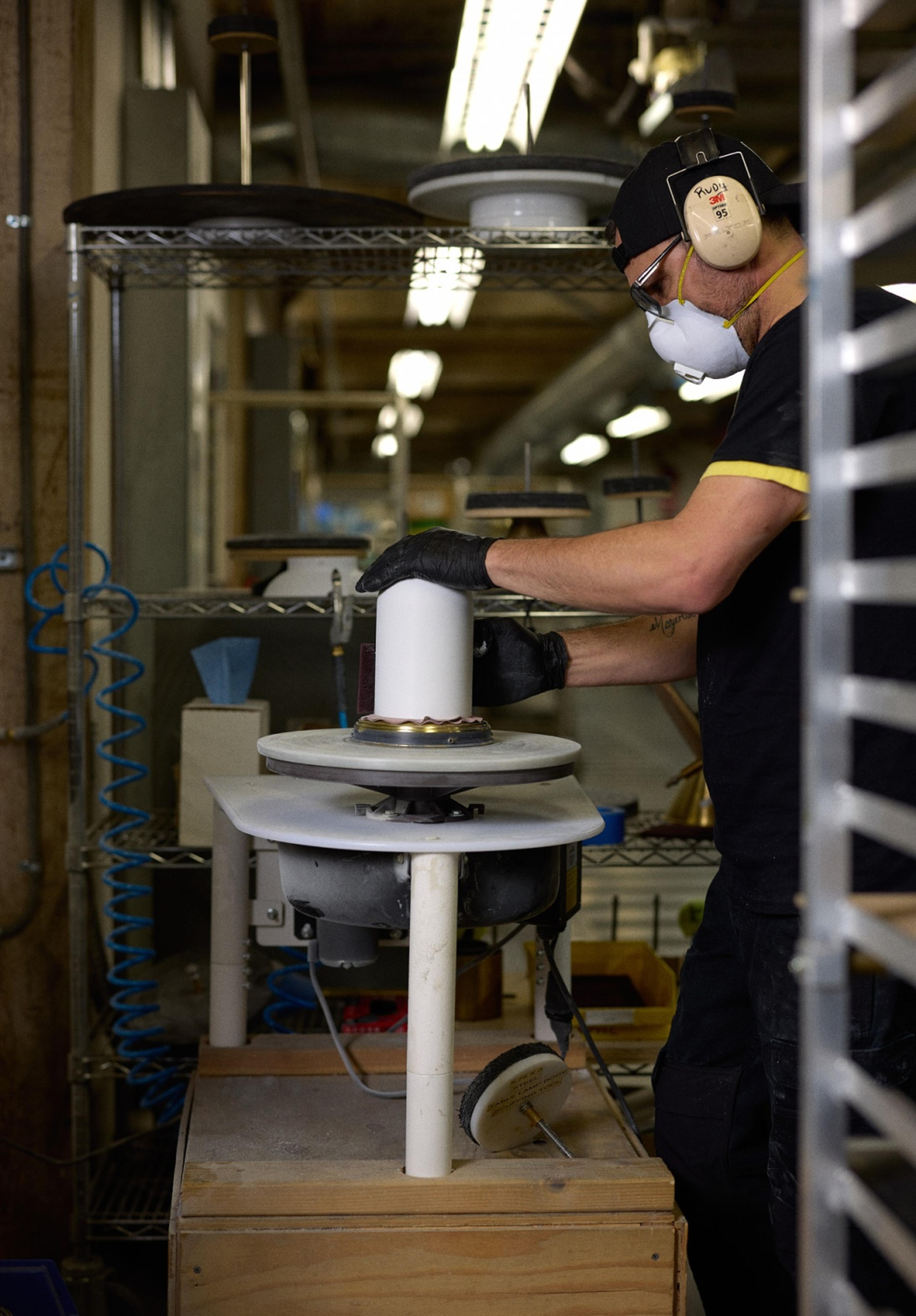 person sanding the finish on Allegheny light for next coat of paint